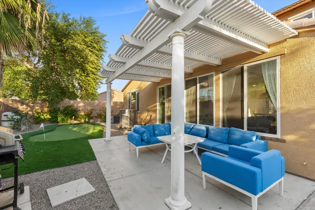 a view of a patio with couches and a table and chairs with plants and garden