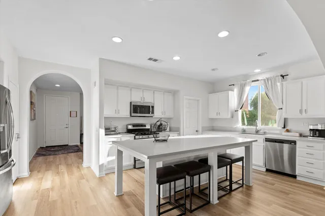 a kitchen with stainless steel appliances a stove a sink a refrigerator and a microwave