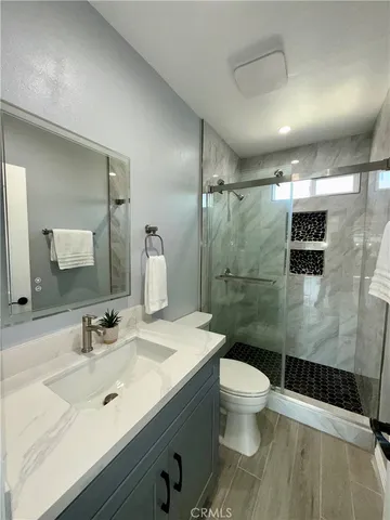 a bathroom with a sink a toilet and shower