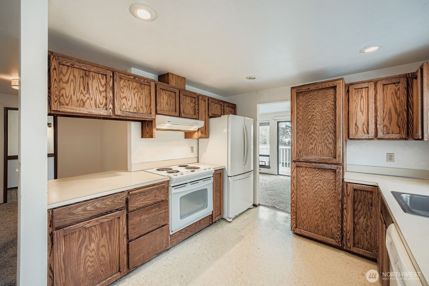 11047 26th Avenue Southwest Seattle, WA 98146 - Photo 5 of 23 a kitchen with a refrigerator sink stove and cabinets
