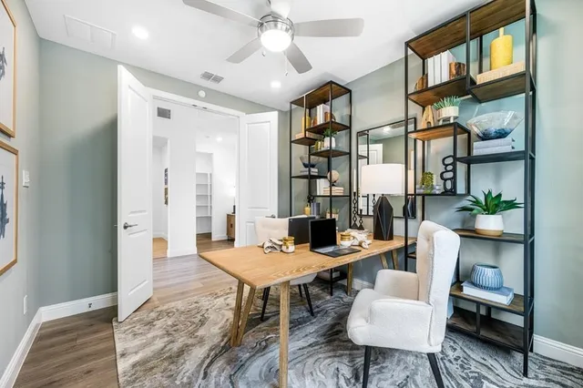 a kitchen with stainless steel appliances a dining table chairs refrigerator and microwave