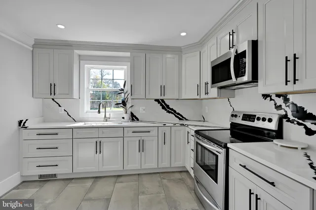 a kitchen with cabinets appliances a sink and a window