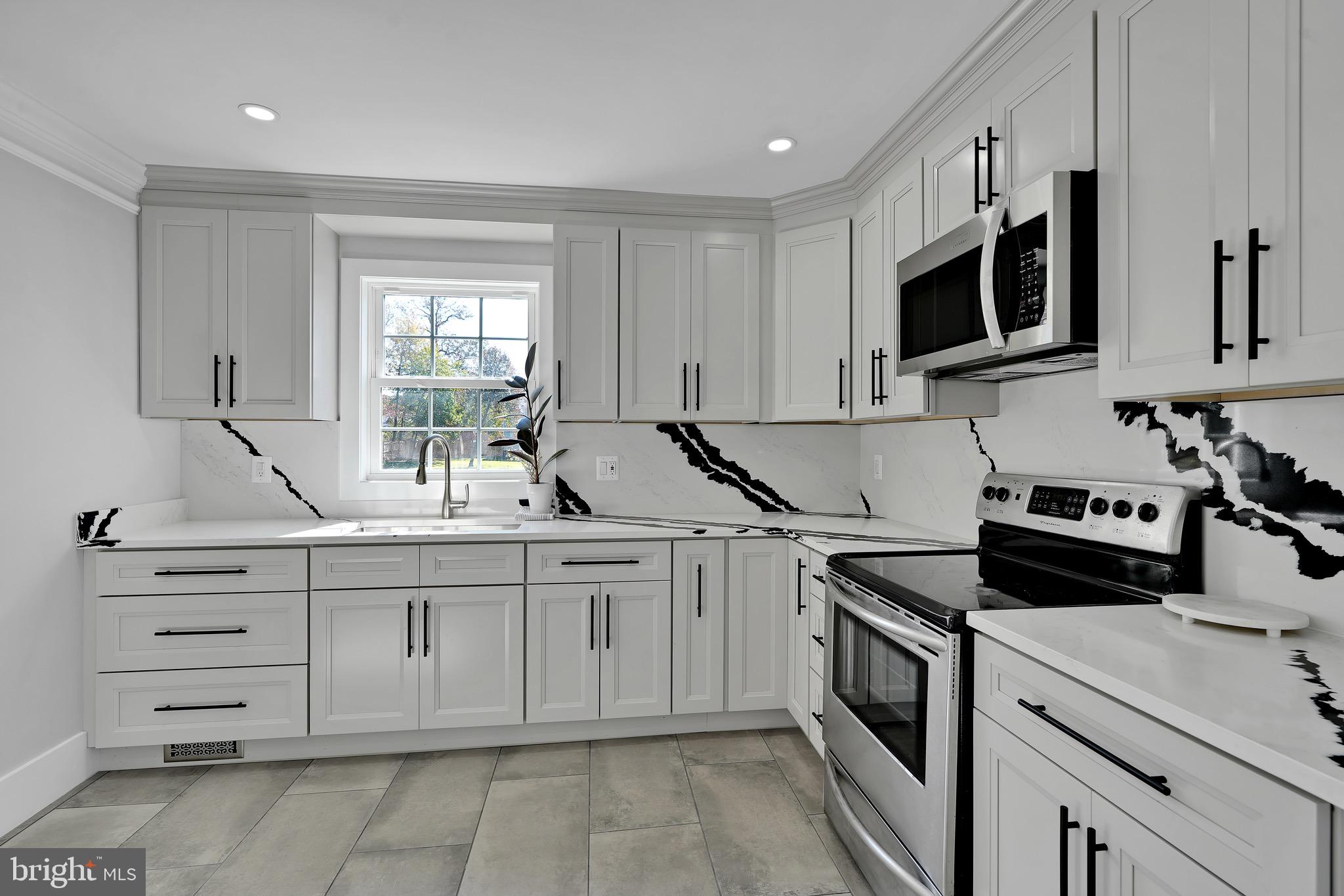 9305 4th Street Lanham, MD 20706 - Photo 11 of 45 a kitchen with cabinets appliances a sink and a window