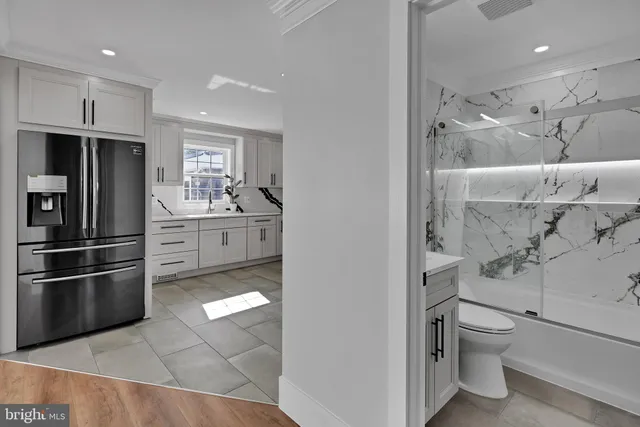 a bathroom with a granite countertop sink a toilet and shower