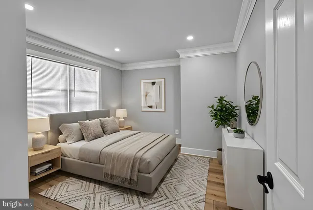 a bedroom with a large bed and a potted plant