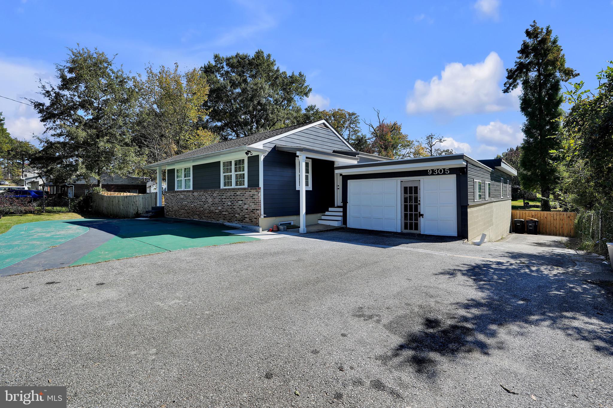 9305 4th Street Lanham, MD 20706 - Photo 3 of 45 a front view of a house with a garden and trees