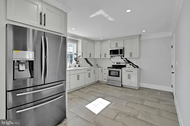 a kitchen with stainless steel appliances kitchen island a refrigerator sink and cabinets