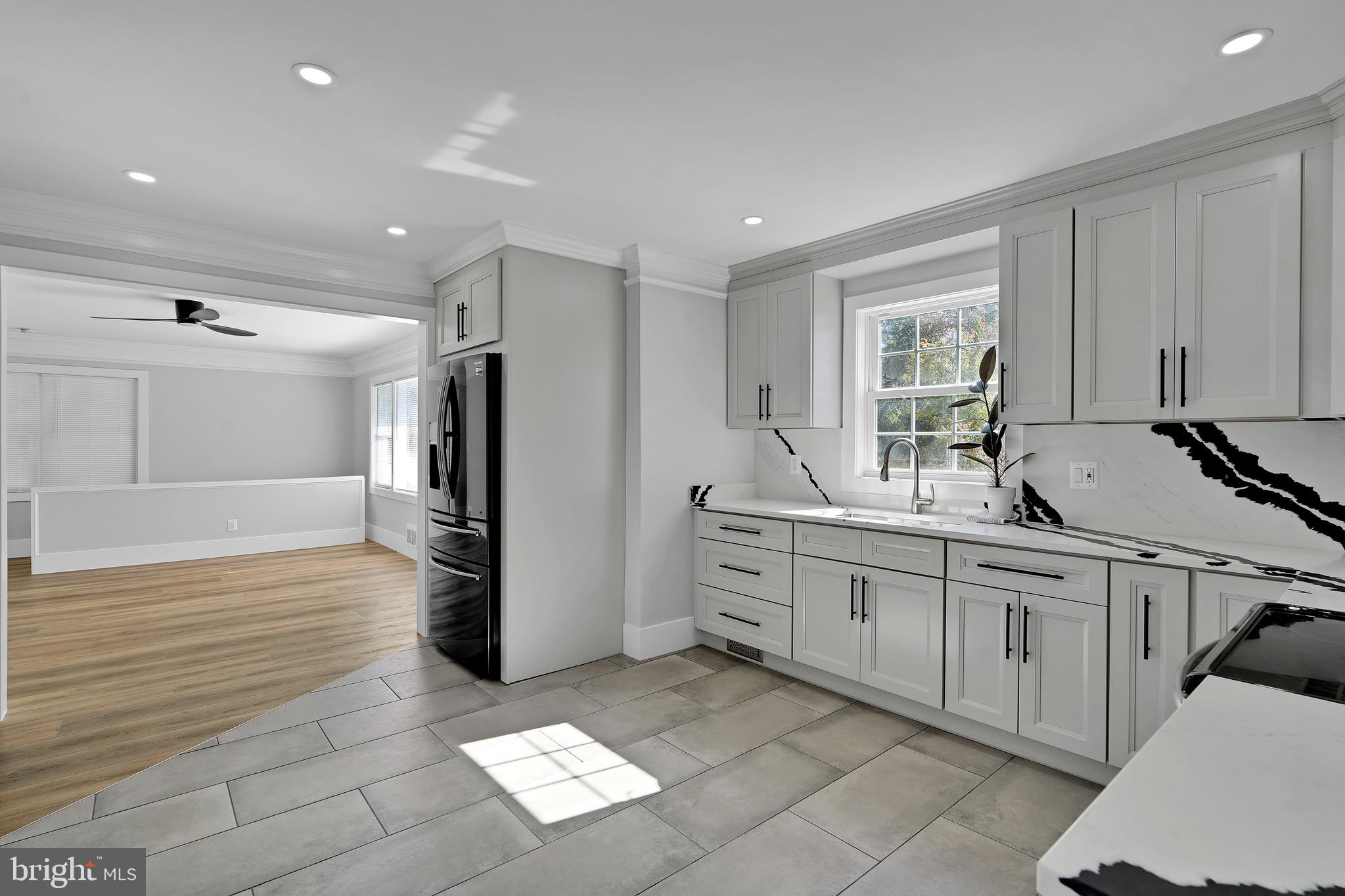 9305 4th Street Lanham, MD 20706 - Photo 10 of 45 a large white kitchen with stainless steel appliances granite countertop a refrigerator and a sink