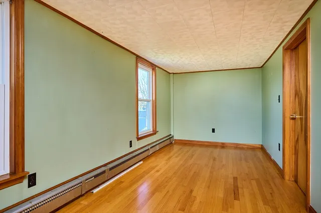 a view of a room with wooden floor and a window