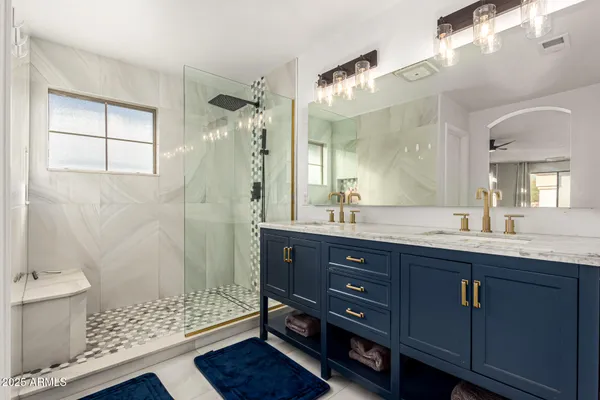 a bathroom with a double vanity sink toilet and shower