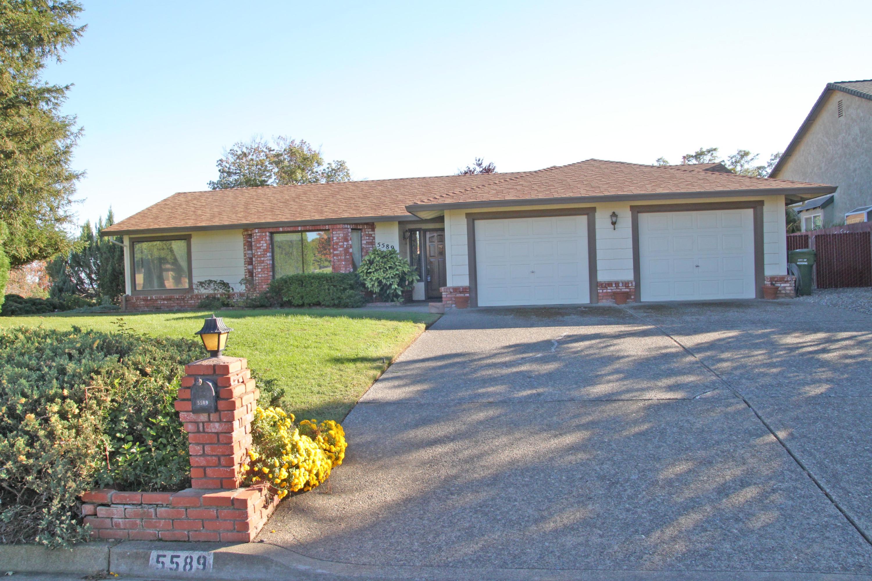 5589 Trish Court Redding, CA 96003 - Photo 1 of 20 a front view of a house with a yard and potted plants