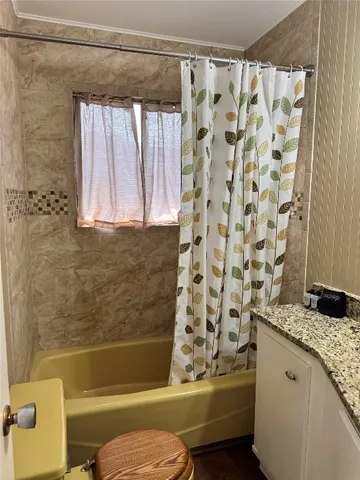 a bathroom with a granite countertop sink toilet and shower