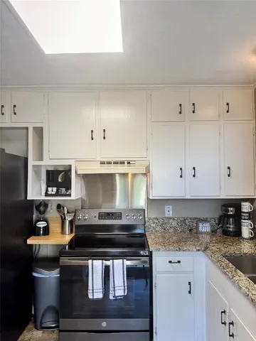 a kitchen with stainless steel appliances granite countertop a stove a sink and a granite counter tops