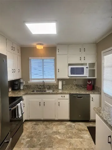 a kitchen with stainless steel appliances granite countertop a sink and stove top oven
