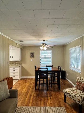 a living room with furniture a dining table and wooden floor