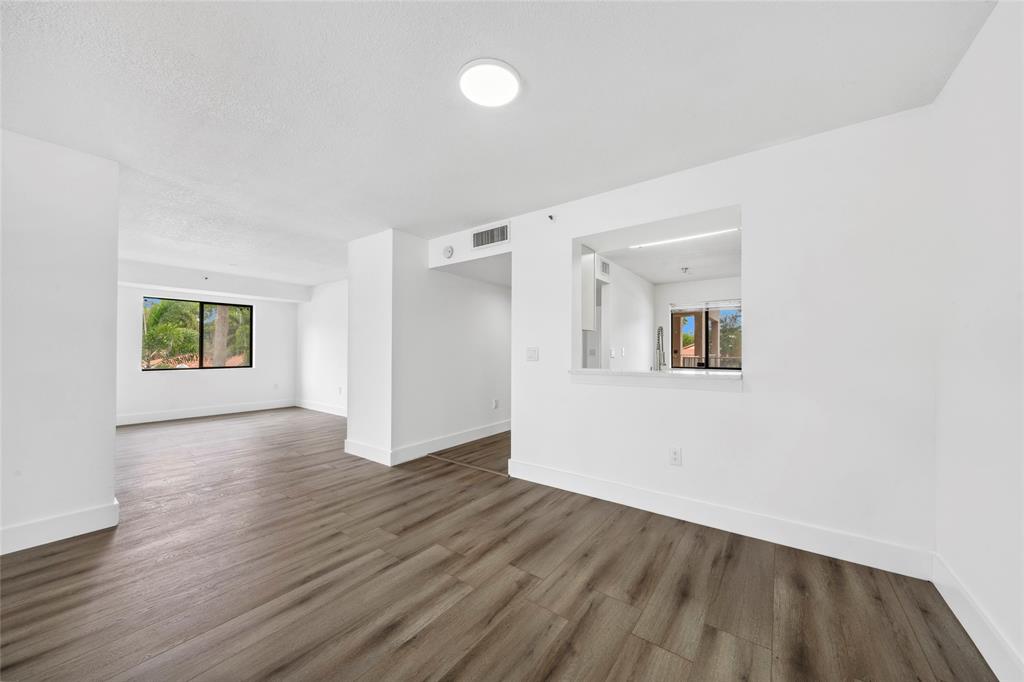 6269 Pointe Regal Circle, Unit 210 Delray Beach, FL 33484 - Photo 13 of 29 an empty room with wooden floor and windows