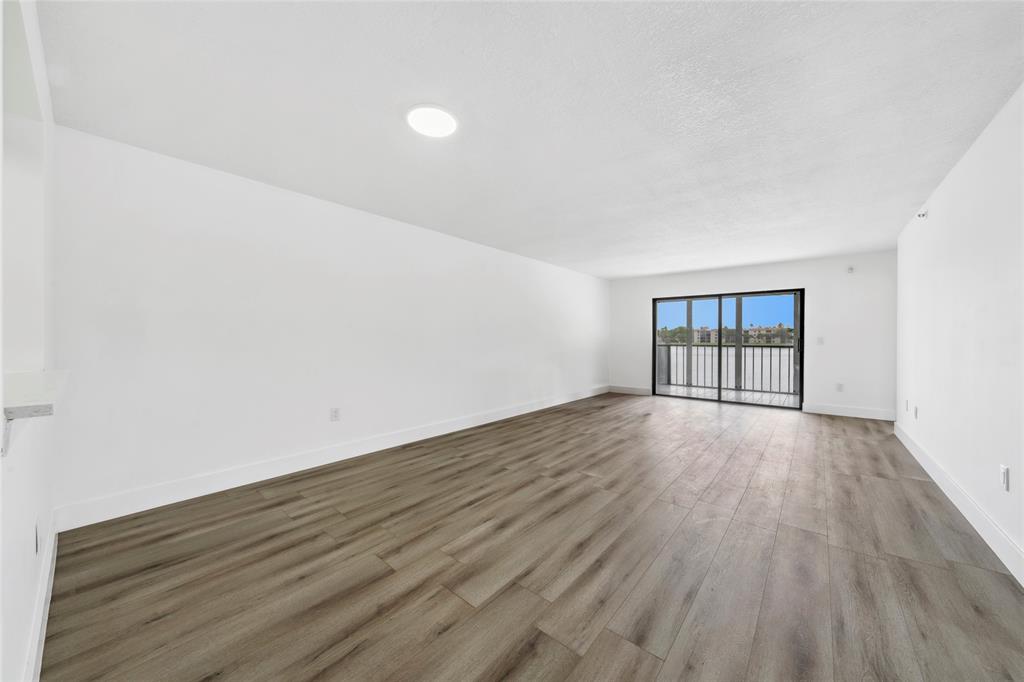 6269 Pointe Regal Circle, Unit 210 Delray Beach, FL 33484 - Photo 15 of 29 an empty room with wooden floor and windows