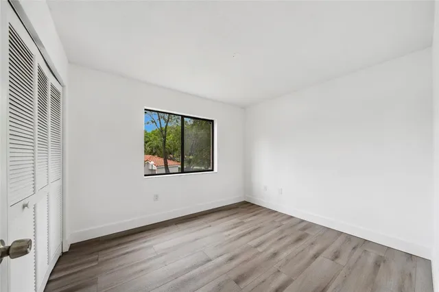 an empty room with wooden floor and window