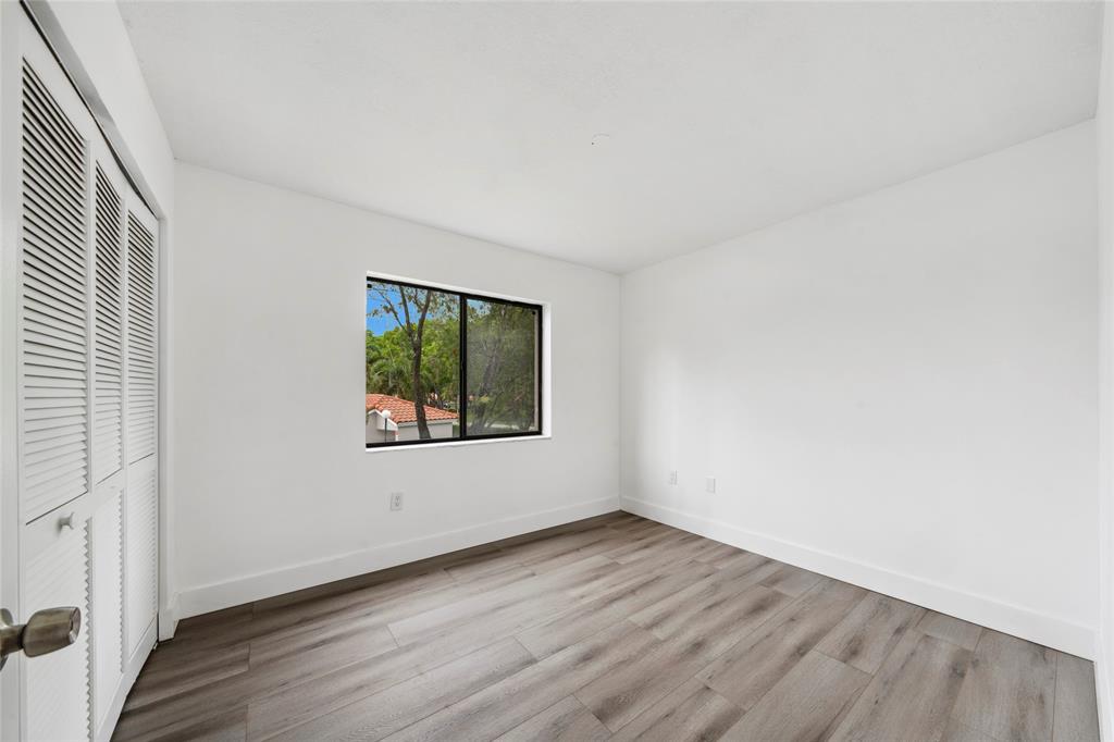 6269 Pointe Regal Circle, Unit 210 Delray Beach, FL 33484 - Photo 18 of 29 an empty room with wooden floor and window