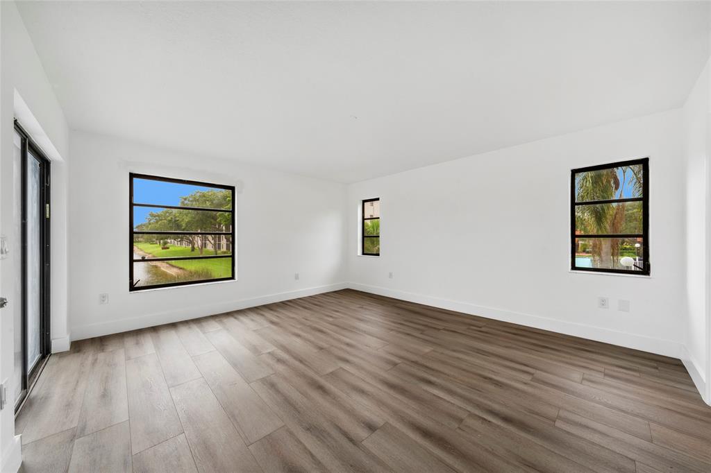 6269 Pointe Regal Circle, Unit 210 Delray Beach, FL 33484 - Photo 20 of 29 a view of an empty room with wooden floor and window