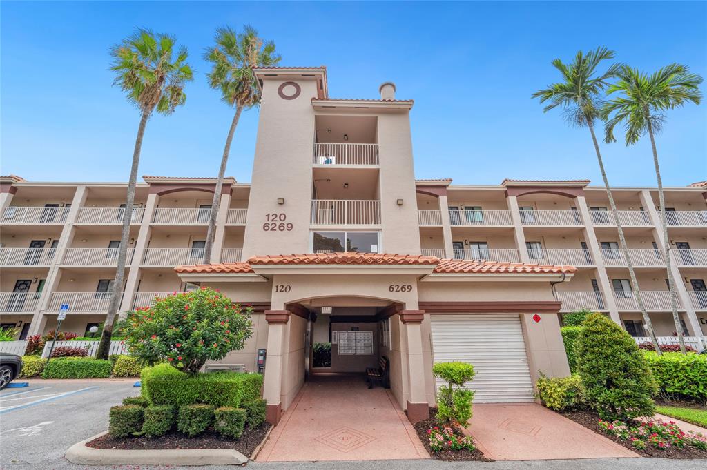 6269 Pointe Regal Circle, Unit 210 Delray Beach, FL 33484 - Photo 3 of 29 a front view of a building with potted plants