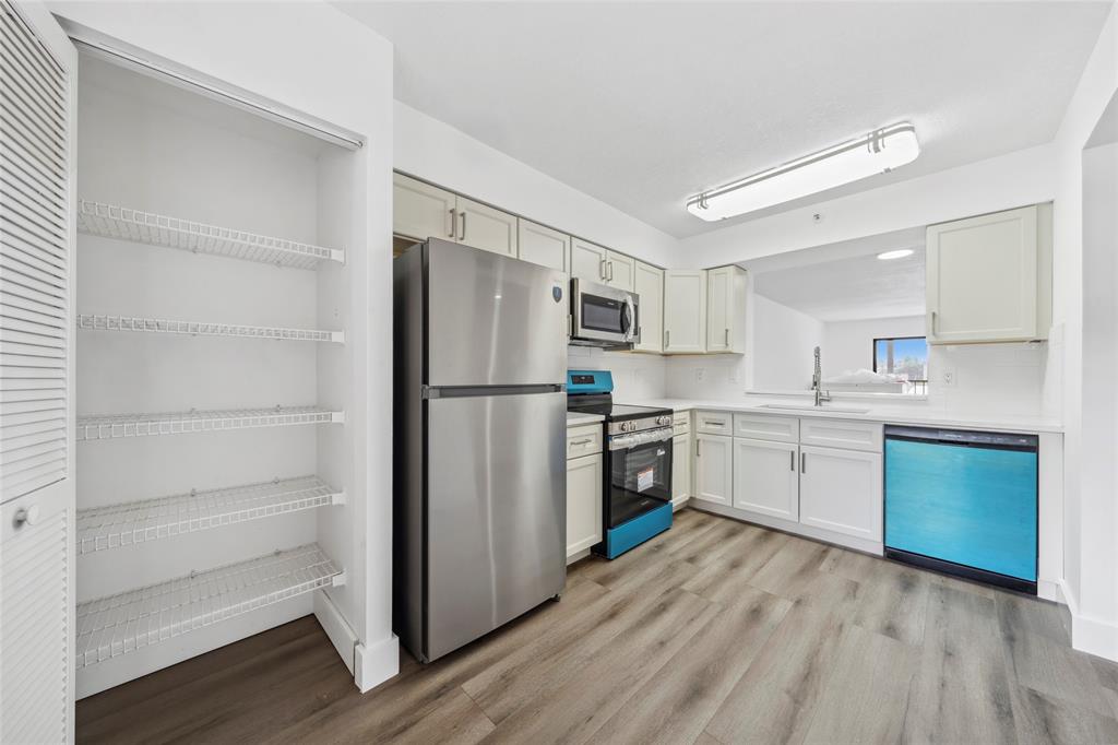 6269 Pointe Regal Circle, Unit 210 Delray Beach, FL 33484 - Photo 6 of 29 a kitchen with a refrigerator and a stove top oven