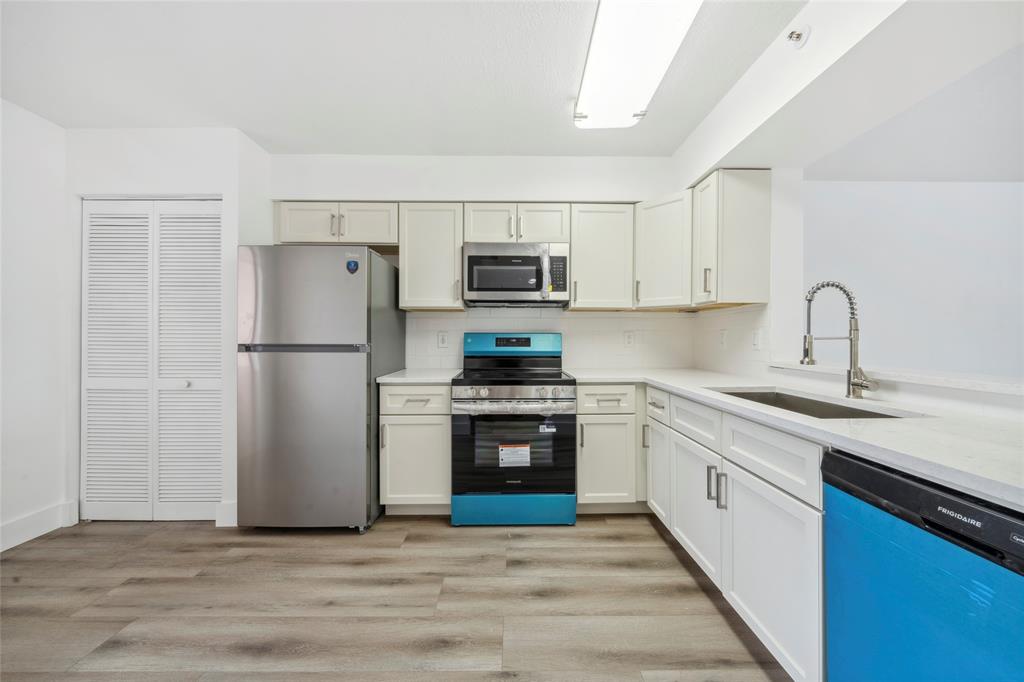 6269 Pointe Regal Circle, Unit 210 Delray Beach, FL 33484 - Photo 7 of 29 a kitchen with refrigerator a stove and a sink