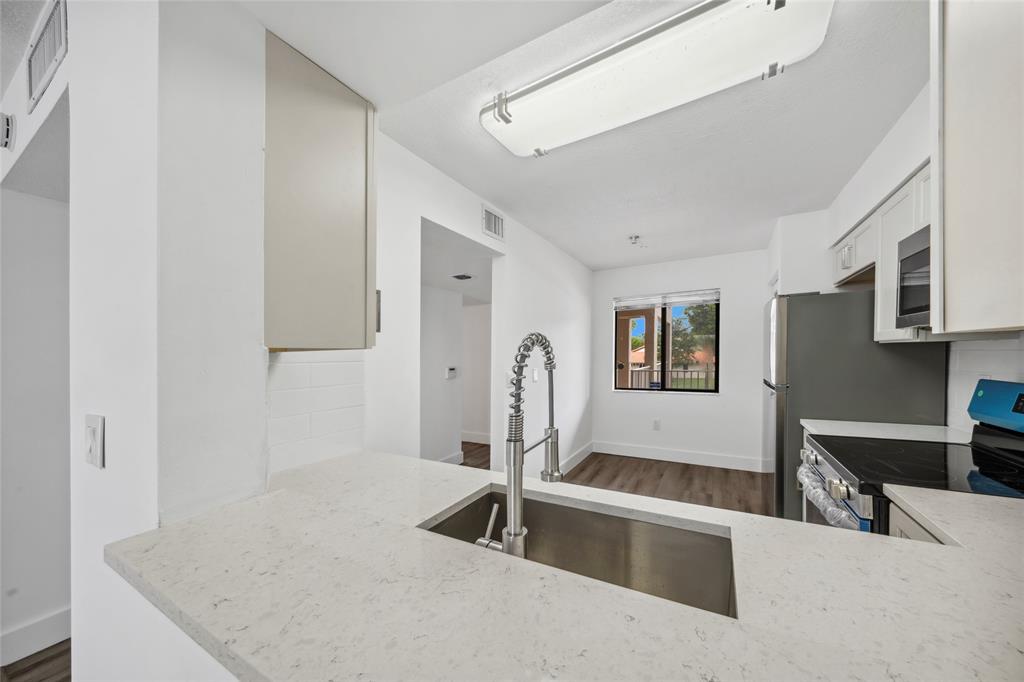 6269 Pointe Regal Circle, Unit 210 Delray Beach, FL 33484 - Photo 8 of 29 a indoor kitchen with stainless steel appliances granite countertop a sink and a refrigerator