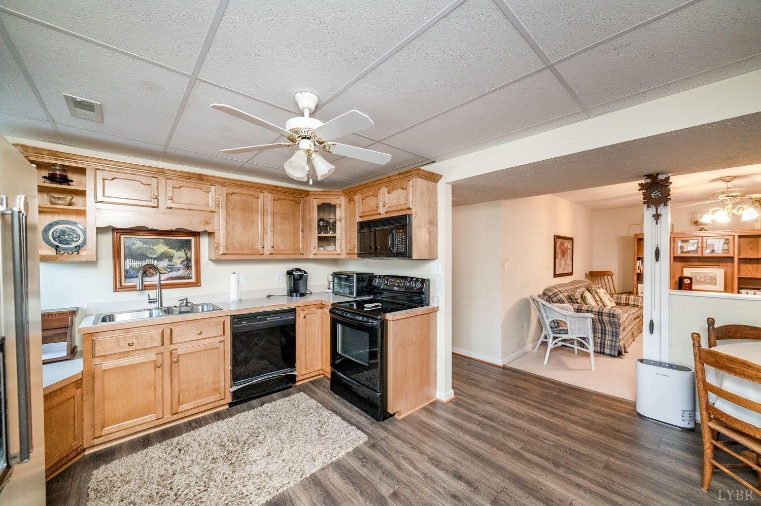 325 Longhill Road Goode, VA 24556 - Photo 46 of 71 a kitchen with stainless steel appliances granite countertop a stove top oven a sink dishwasher a dining table and chairs with wooden floor