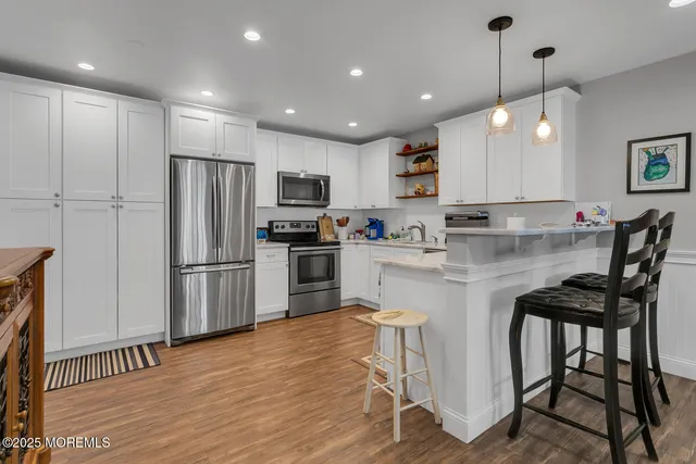 a kitchen with kitchen island white cabinets and stainless steel appliances