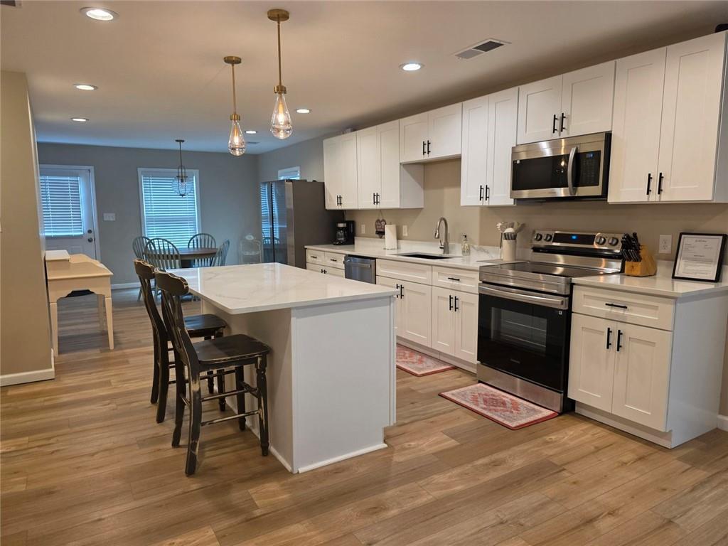 722 Lacy Street Monroe, GA 30655 - Photo 6 of 19 a kitchen with a stove a sink a dining table and chairs