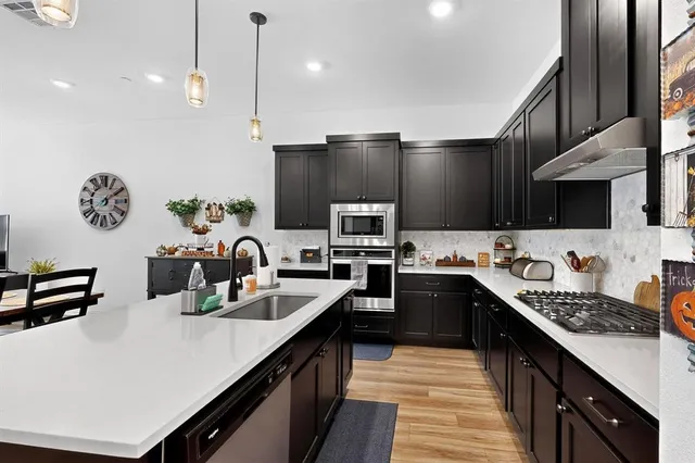 a kitchen with stainless steel appliances a sink stove and refrigerator