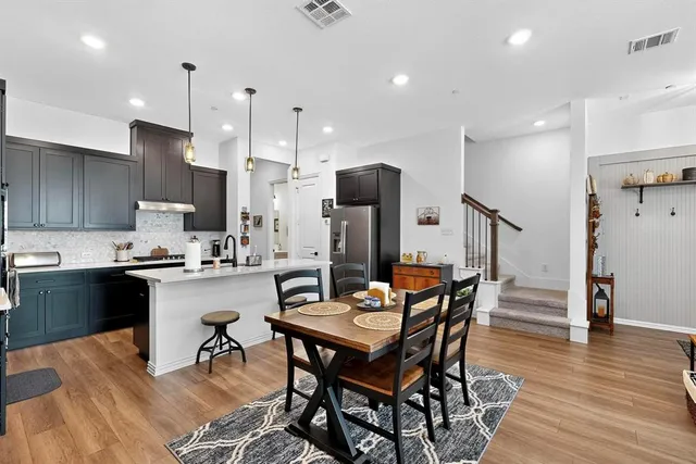 a living room with furniture a large window and wooden floor