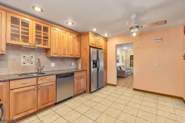 a kitchen with granite countertop a refrigerator and a sink