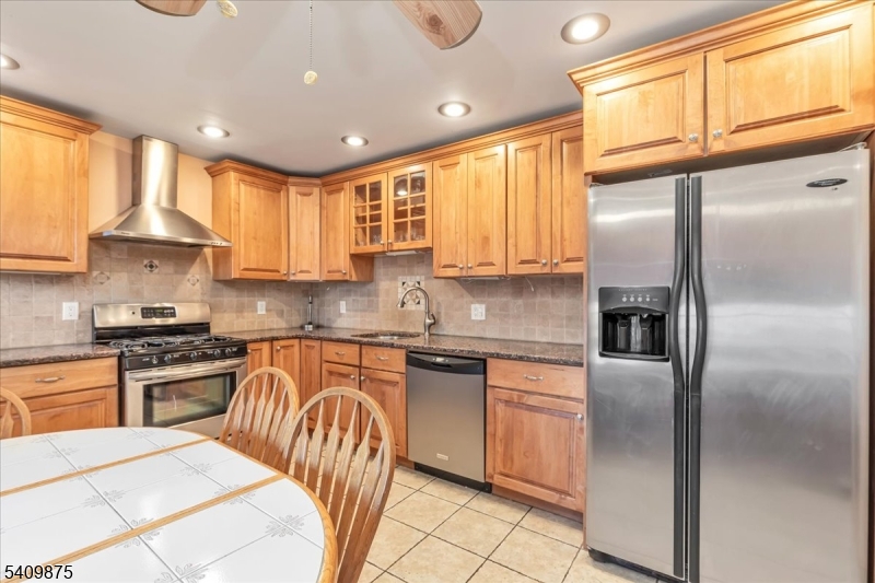 29 Manitou Circle Westfield, NJ 07090 - Photo 18 of 35 a kitchen with stainless steel appliances granite countertop a refrigerator a sink dishwasher a stove and white cabinets with wooden floor
