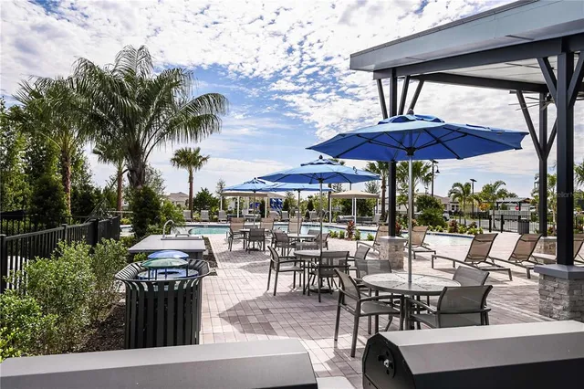 a view of a patio with chairs and table under an umbrella