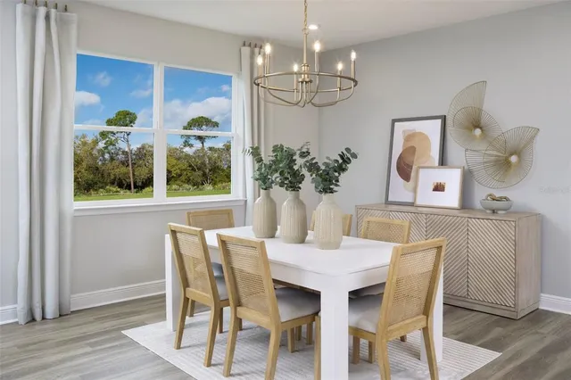 a view of a dining room with furniture a chandelier and wooden floor