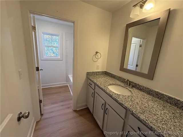 a bathroom with a granite countertop sink and a mirror