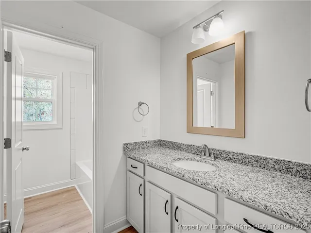a bathroom with a granite countertop sink and mirror with window