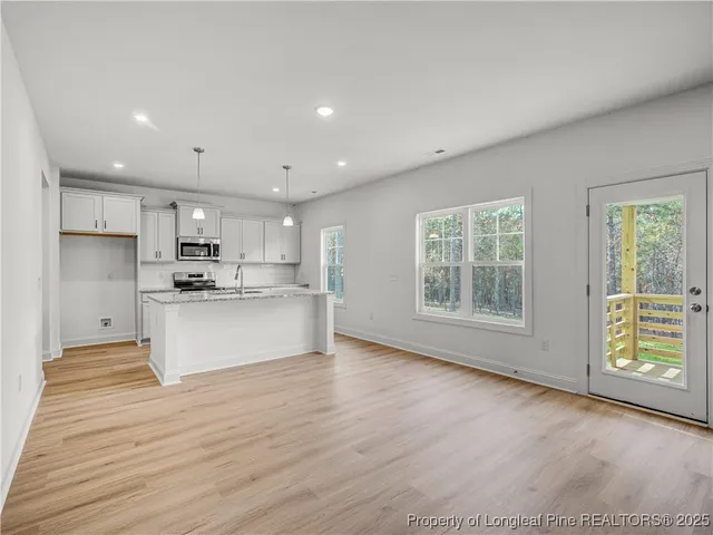 a view of kitchen with kitchen island wooden cabinets and refrigerator