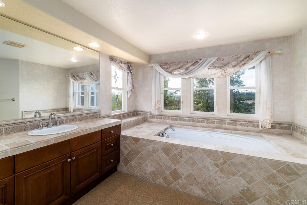 6237 Paseo Privado Carlsbad, CA 92009 - Photo 10 of 29 a spacious bathroom with a tub sink and mirror