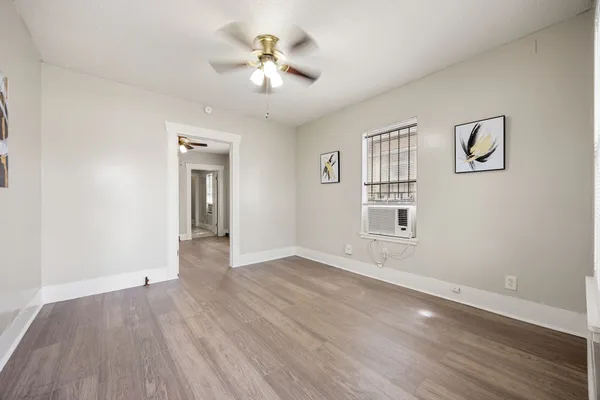 an empty room with wooden floor and windows