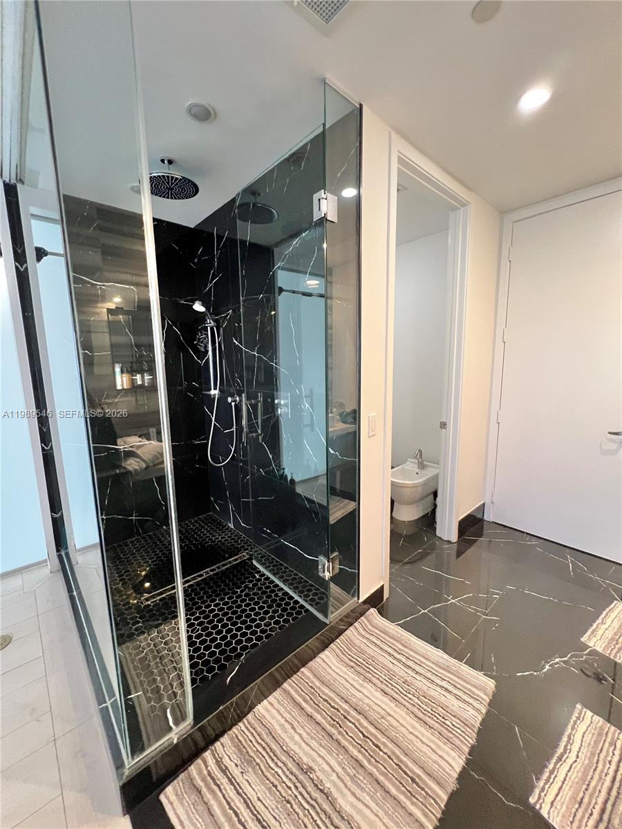 1100 Biscayne Boulevard, Unit 5804 Miami, FL 33132 - Photo 3 of 6 a bathroom with a glass shower door