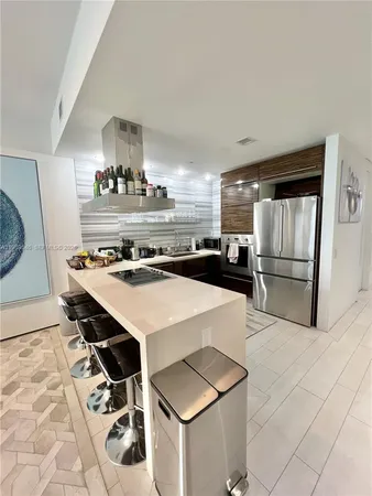 a kitchen with kitchen island a stove a sink and a refrigerator