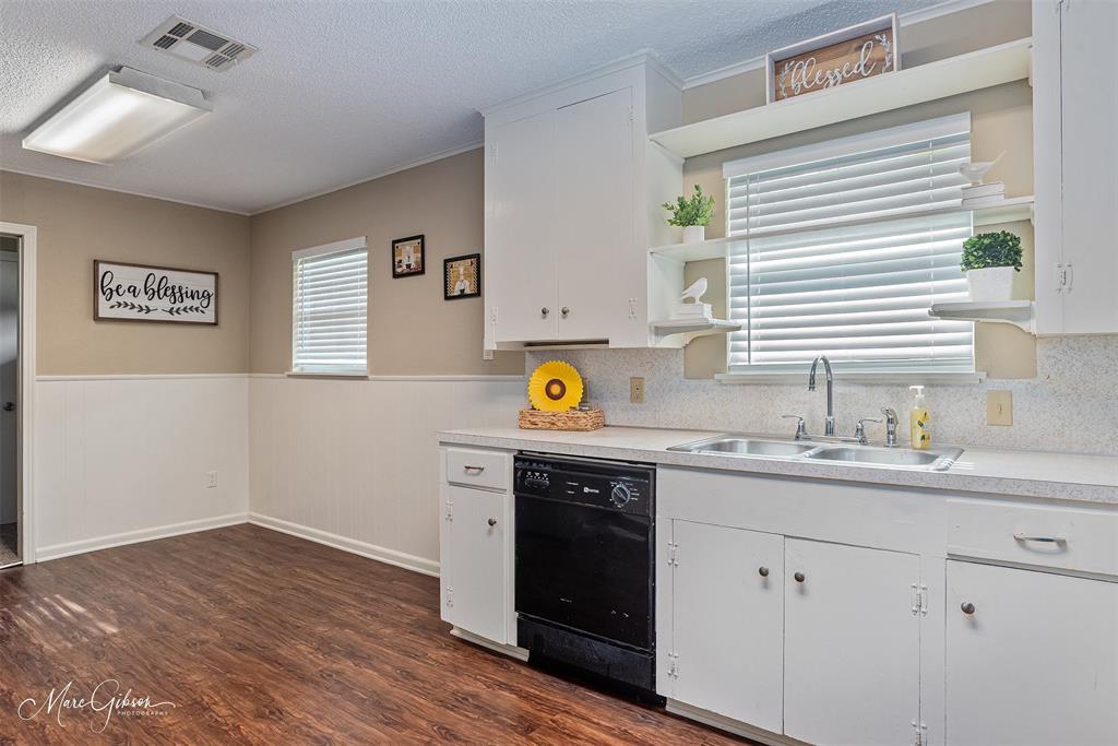 9342 Dean Road Shreveport, LA 71118 - Photo 9 of 18 Kitchen area featuring wood-finish flooring, white cabinetry, and a dual basin sink with an integrated dishwasher