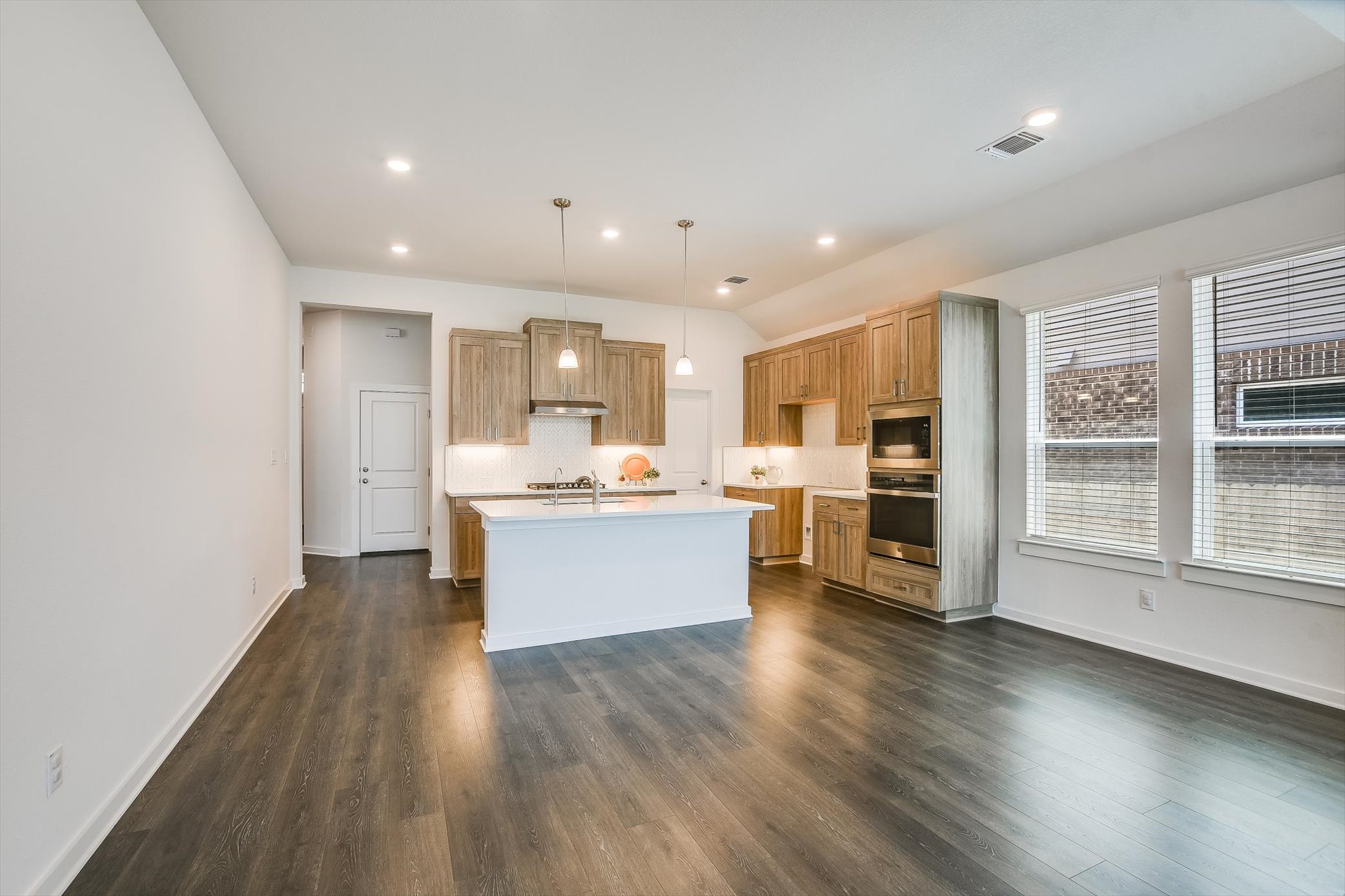 205 Wingstem Way Georgetown, TX 78633 - Photo 7 of 29 Open-concept kitchen and living area featuring dark wood-finish flooring.