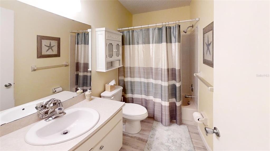 8678 Southwest 95 Street, Unit B Ocala, FL 34481 - Photo 21 of 22 a bathroom with a sink a toilet and shower curtain