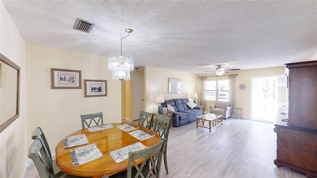 8678 Southwest 95 Street, Unit B Ocala, FL 34481 - Photo 6 of 22 a living room with furniture a dining table and a chandelier