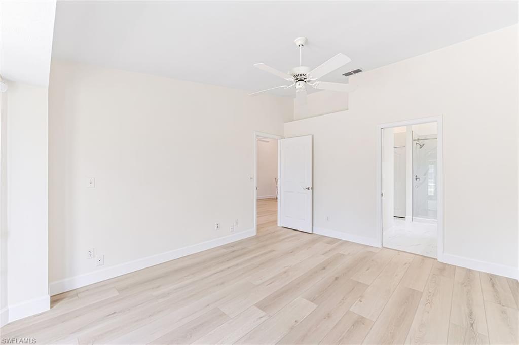 8562 Mustang Drive, Unit 31 Naples, FL 34113 - Photo 15 of 44 Unfurnished bedroom featuring connected bathroom, light wood-type flooring, ceiling fan, baseboards, and visible vents
