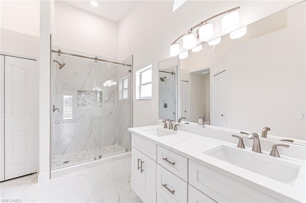 8562 Mustang Drive, Unit 31 Naples, FL 34113 - Photo 16 of 44 Bathroom with double vanity, a marble finish shower, and a sink